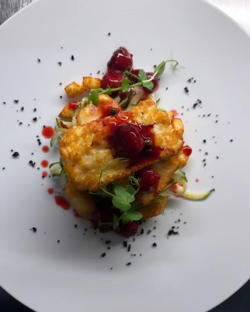 Knusprig angerichtetes Gericht mit Gemüse, Beeren und Kräutern